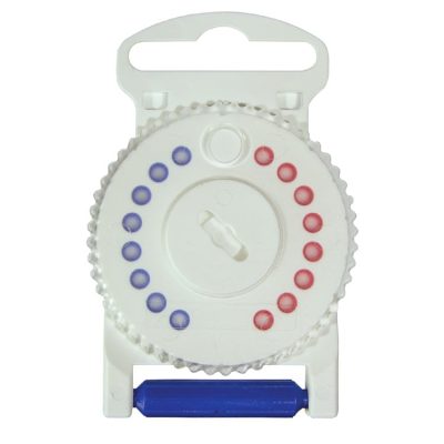 A close-up of the WaxGuard HF3, a white circular medication reminder dial with blue and red dots, housed in a white plastic holder. It features a central rotating mechanism and a blue latch at the bottom.